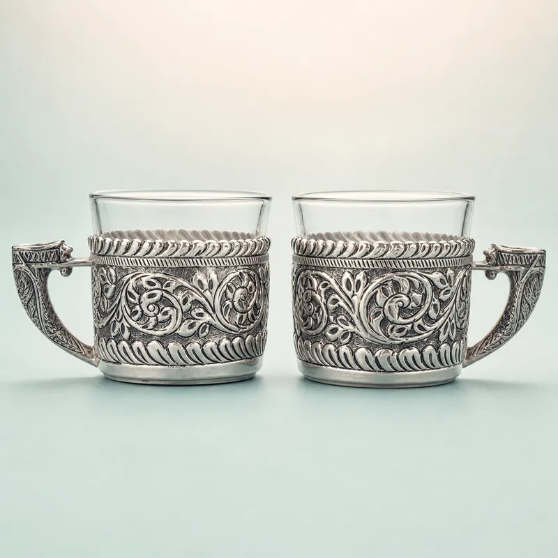 Silver-Embossed Borosil Tea/Coffee Cup Pair (clear glass + oxidised floral sleeve) - 925 Sterling Silver on seaglass background