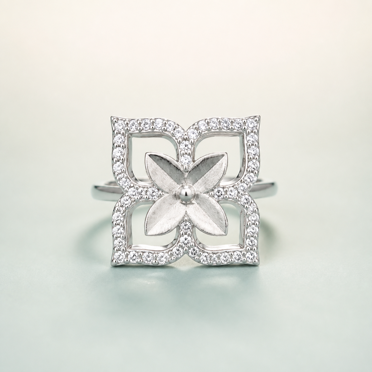 Layered Four-Petal Flower CZ Ring (bright rhodium silver · brushed satin + pavé) - 925 Sterling Silver on seaglass background