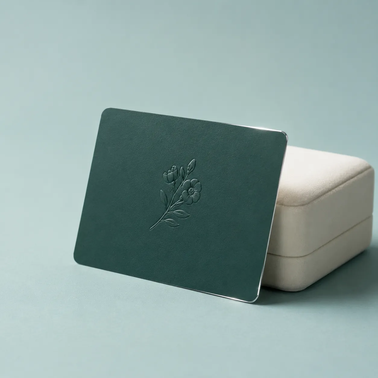 An emerald DIYAM gift card with a silver foil edge beside a jewellery box