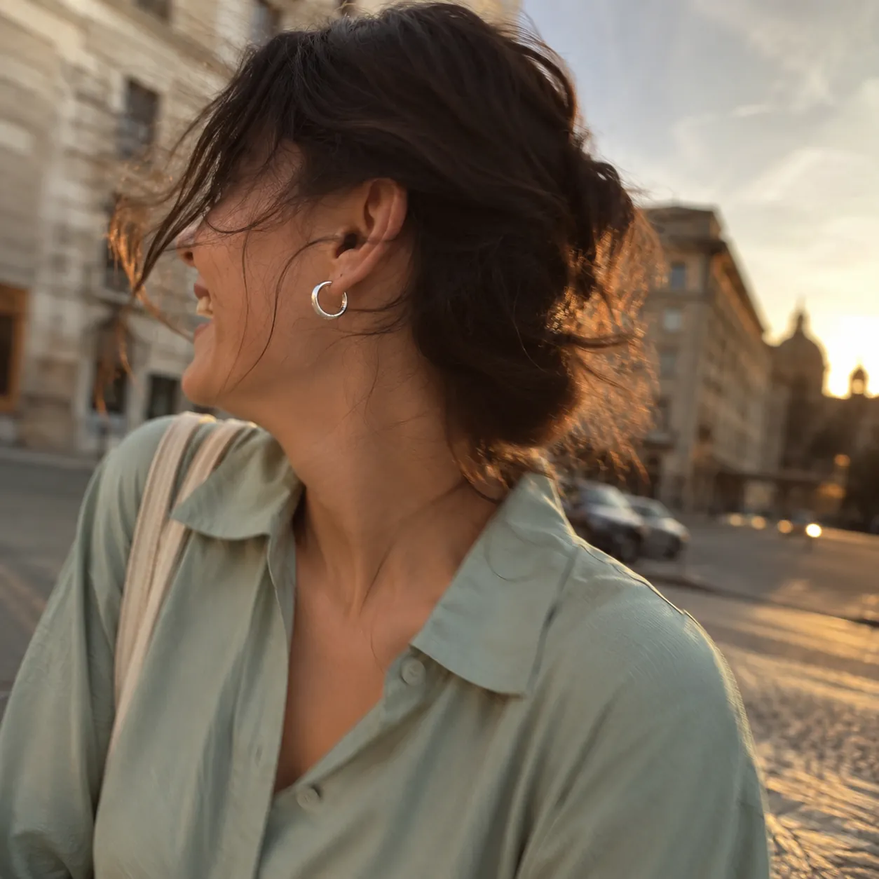 A friend mid-turn at golden hour, silver hoops glinting