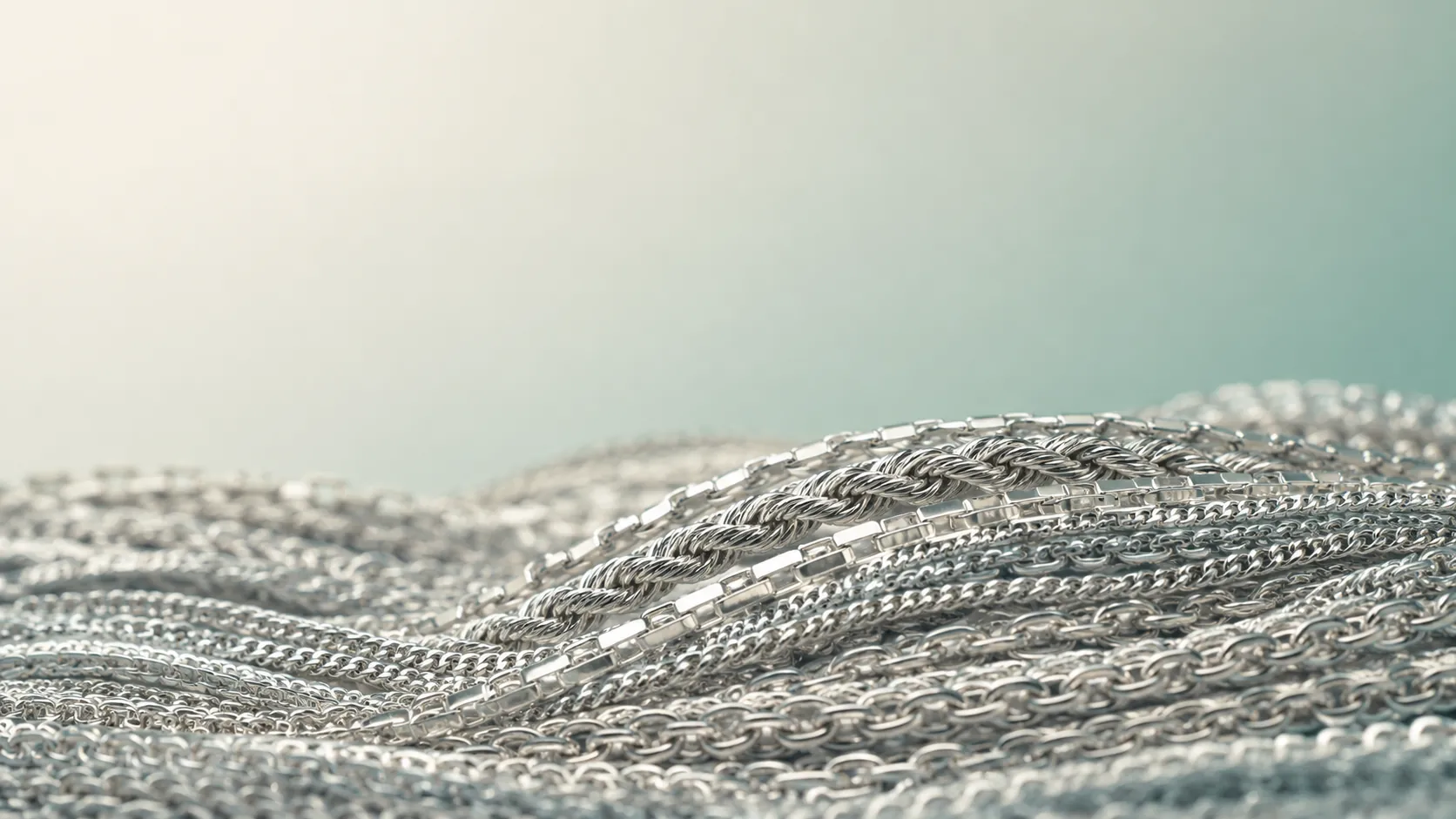Layered silver chain links in macro, rolling like dunes