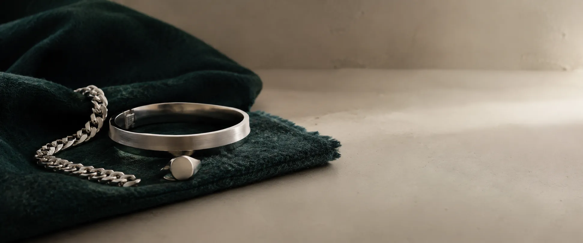 Heavy curb chain, brushed kada and signet ring on deep emerald wool