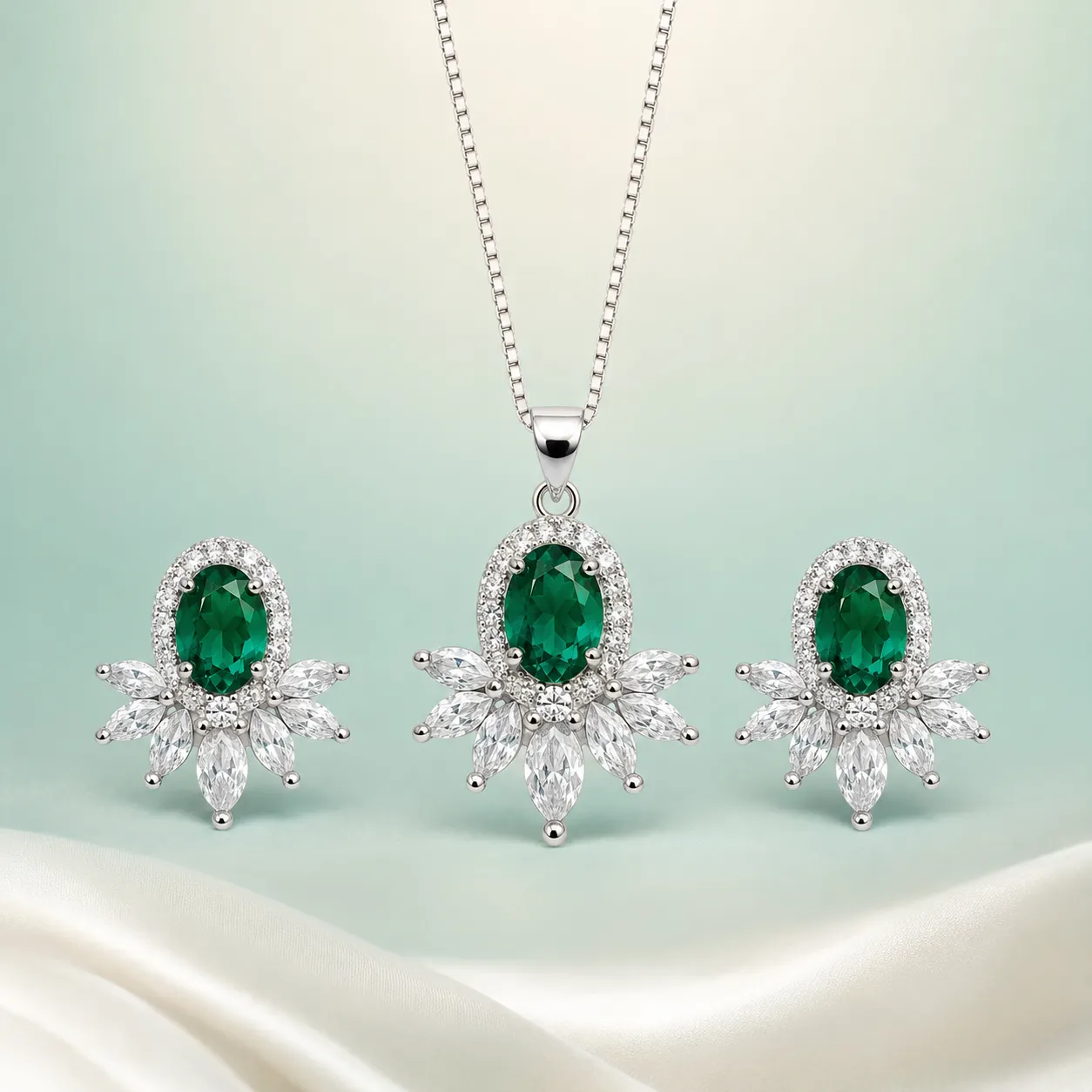 Emerald Oval-Halo Floral Set — bright silver, emerald-green centres — on seaglass background